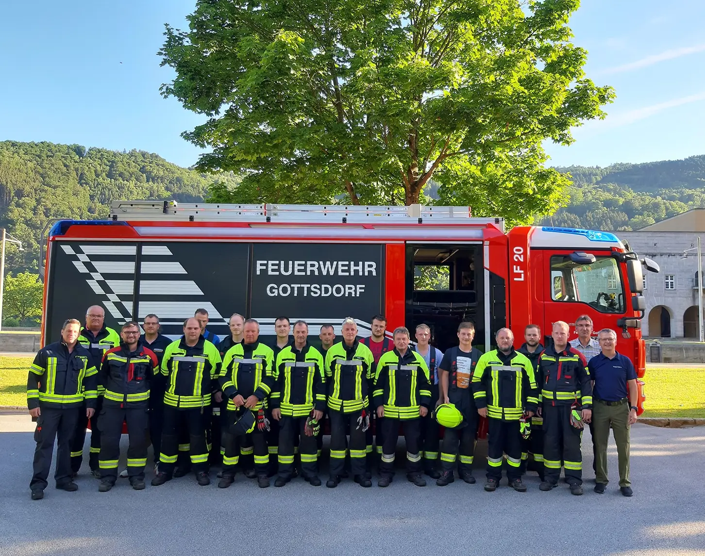 Vor dem roten Feuerwehrauto stehen die Manschaften der Feuewehr Gottsdorf und Obernzell mit Brandschutzwart Manfred Rossgatterer vom Kraftwerk Jochenstein.